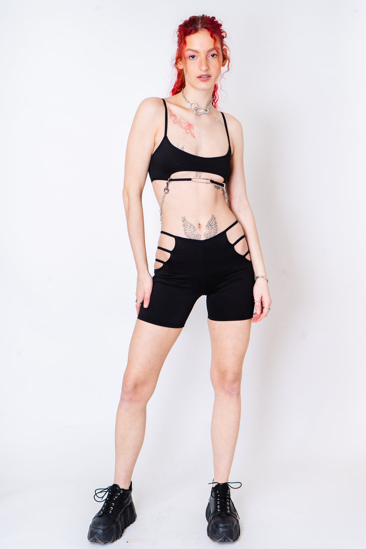 Black cotton biker shorts iwth hip cutouts and strappy details.