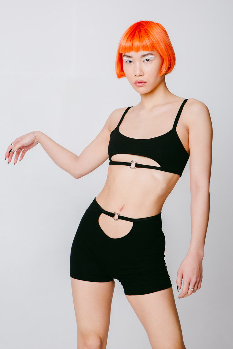Black booty shorts with a cutout and a piercing closure.