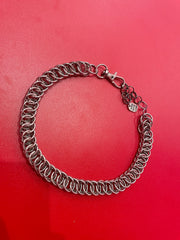 A close-up of a simple yet stunning chain mail choker, featuring a delicate and intricate weave. The choker rests gracefully against a neutral backdrop, showcasing its elegant and versatile design.