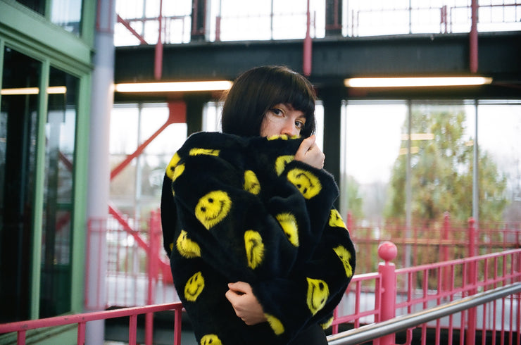 black jacket with yellow smiley faces and buckles