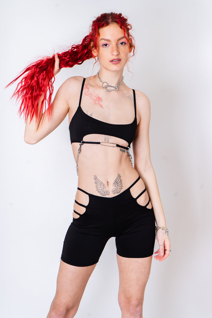 Black crop top with safety pin closure and silver chain detail.