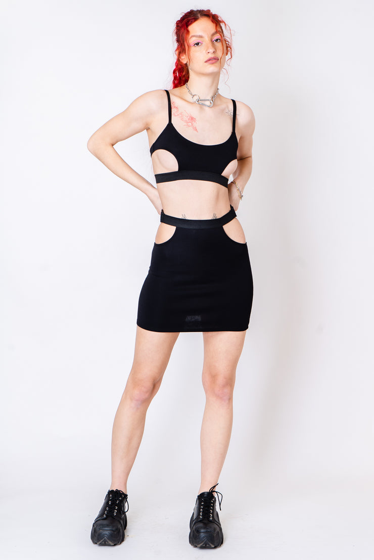 Black mini skirt with hip cutouts.