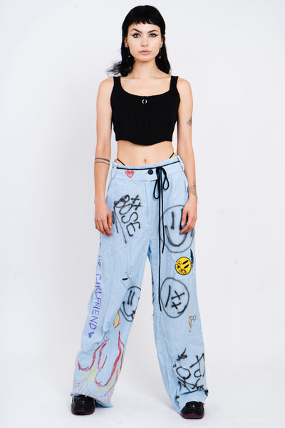 Light wash blue jeans with a wide cut and grafitti print.