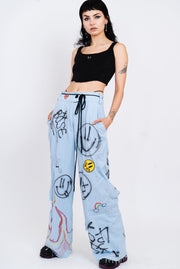 Light wash blue jeans with a wide cut and grafitti print.