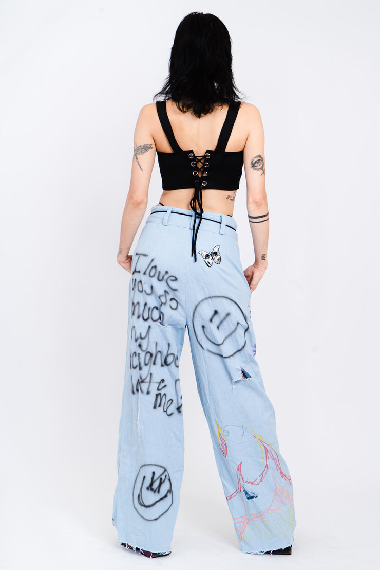 Light wash blue jeans with a wide cut and grafitti print.