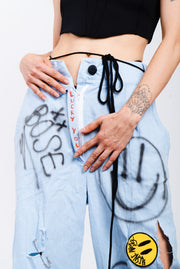 Light wash blue jeans with a wide cut and grafitti print.