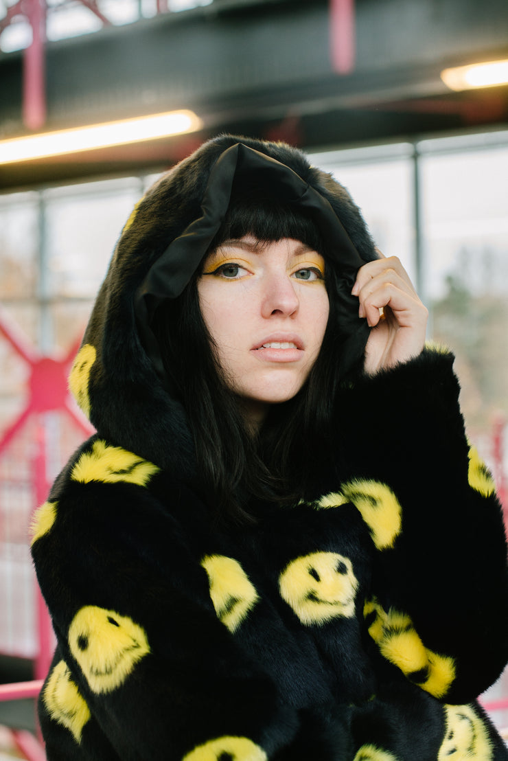 black jacket with yellow smiley faces and buckles