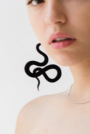 close up of sleek black snake hanging earrings