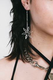 Clear star shaped earrings hanging on a silver chain.