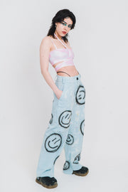 Low rise jeans out of light wash denim with black smileys.
