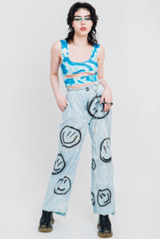 Low rise jeans out of light wash denim with black smileys.