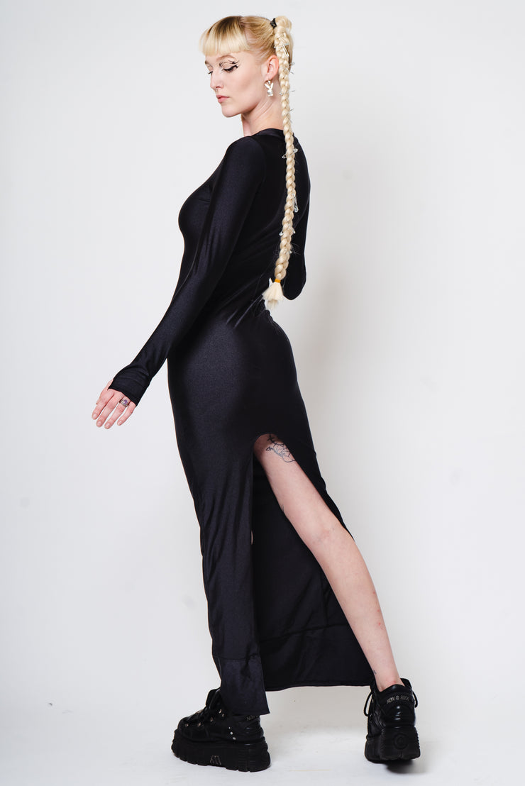 Floor length tight black dress with high slit.