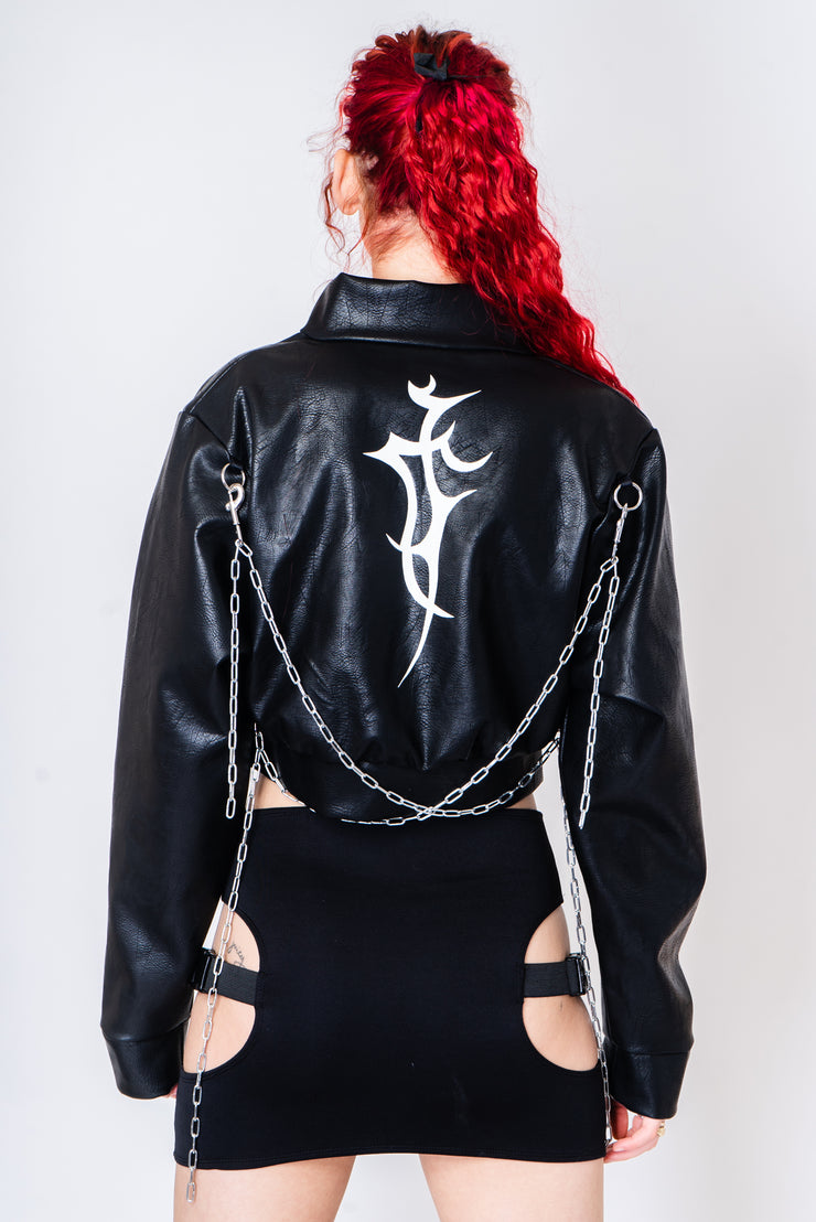 Black vegan leather jacket with silver chains and a tattoo print.