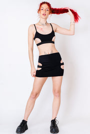 Black mini skirt with side cutouts and buckle detailing.