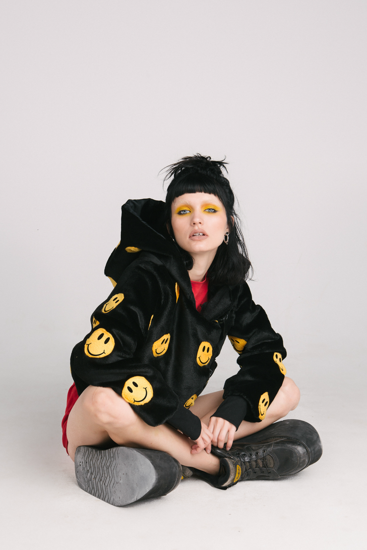 black jacket with yellow smiley faces and buckles