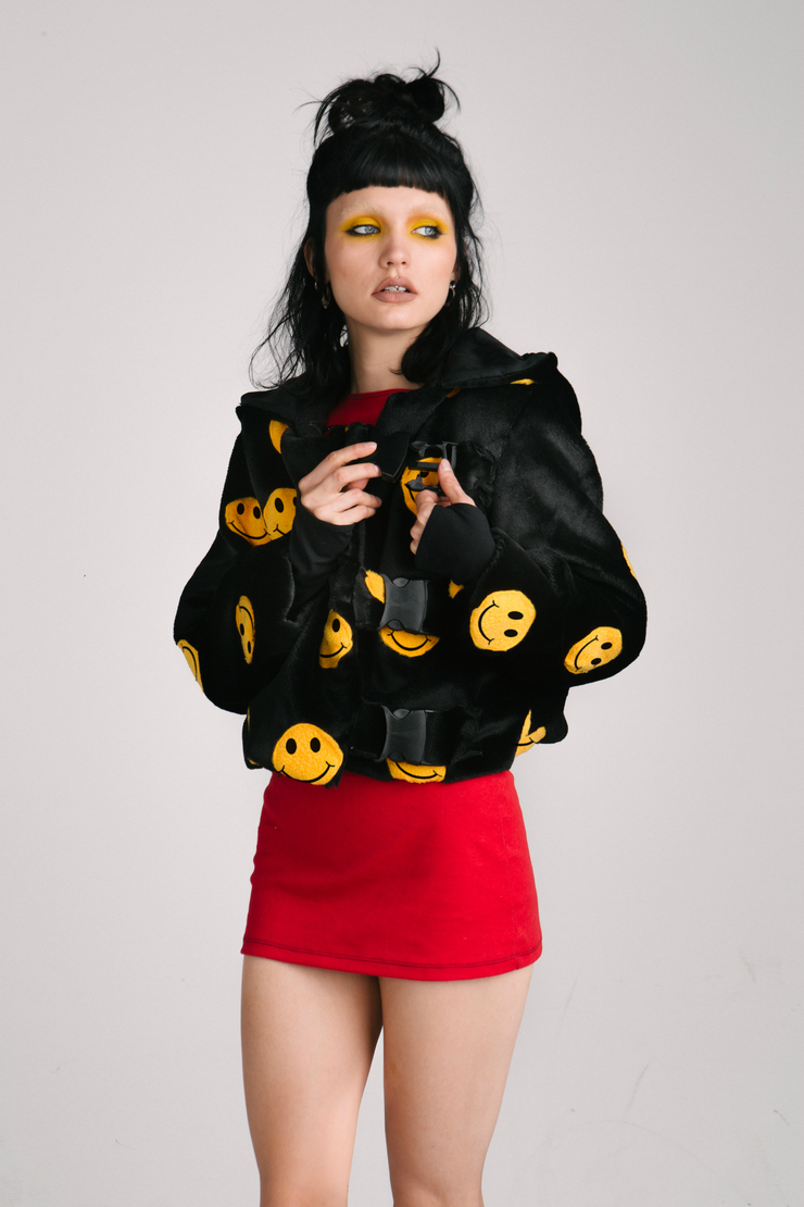 black jacket with yellow smiley faces and buckles
