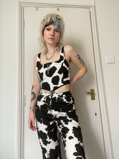 Black and white cow print corset with padlock detail.