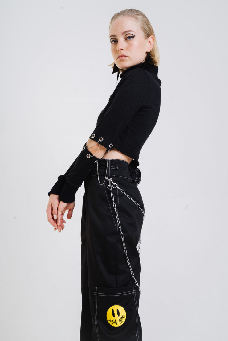 Black long sleeve top with chain closures on the sleeves.